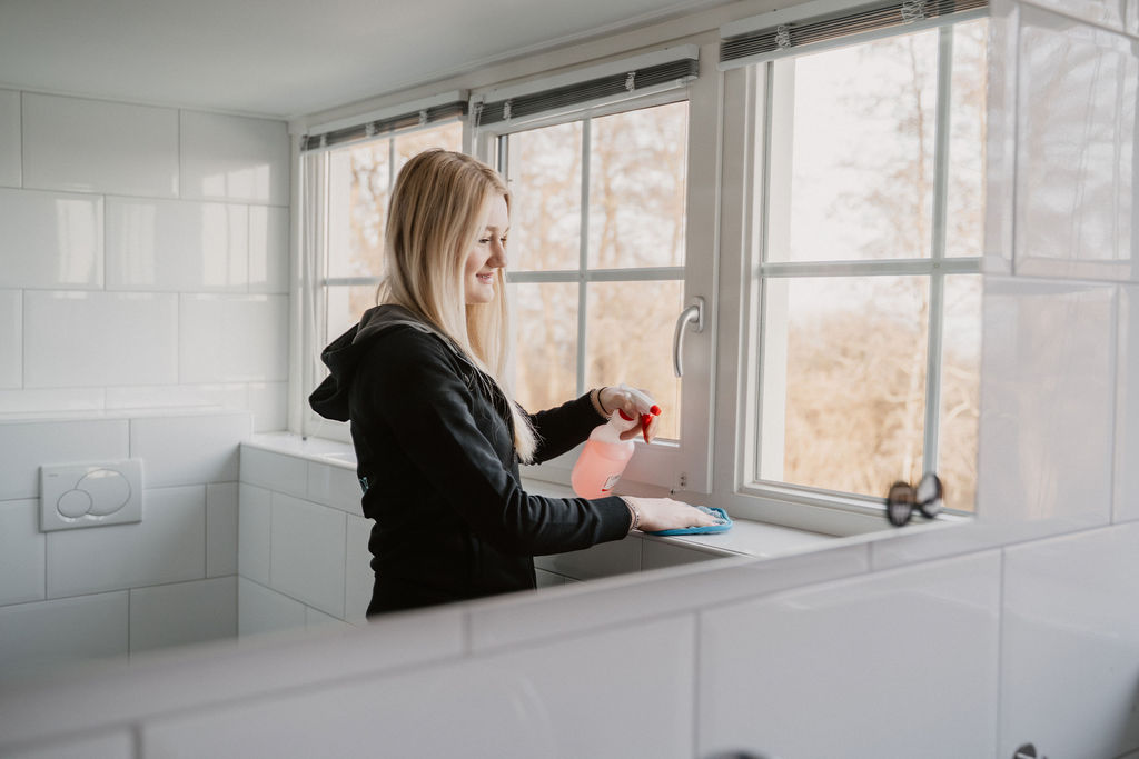 Medewerker van Poetshier maakt een raam schoon