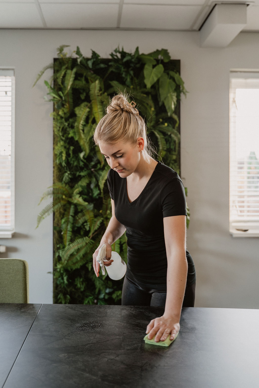 Medewerker van Poetshier maakt een tafel schoon